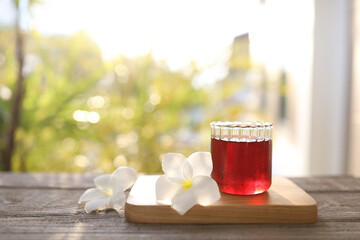 Red grape juice and flower on wooden table