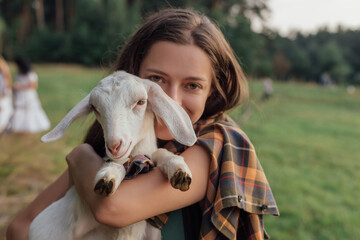 Beautiful woman with small goat in countryside have friendship in nature