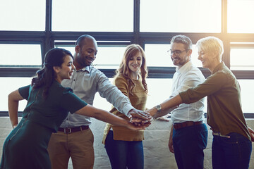 Are you ready, team. Shot of a group of colleagues joining their hands in solidarity at work.