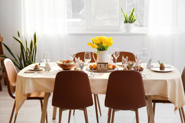 Festive table setting with beautiful tulips in light room