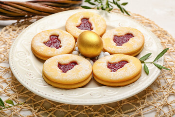 Plate with delicious Easter cookies on light background