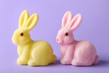 Different cute Easter bunnies on purple background