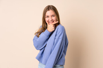 Teenager Ukrainian girl isolated on beige background happy and smiling