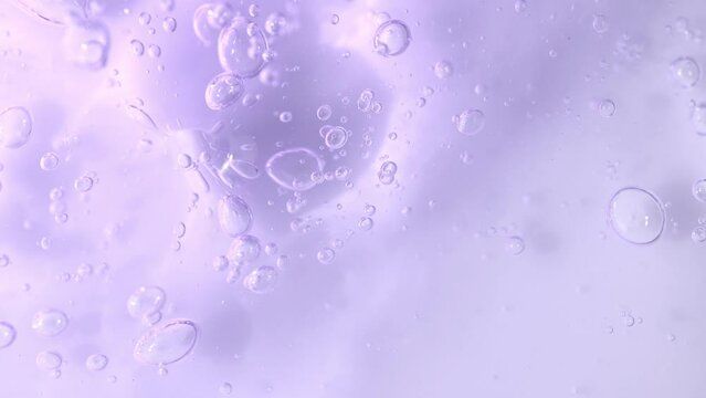 Bakuchiol serum transparent texture with slowly moving bubbles, purple liquid skincare cosmetic gel, macro shot.