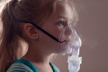 cute little girl is sick. lung disease, covid-19. child does the inhalation procedure with...