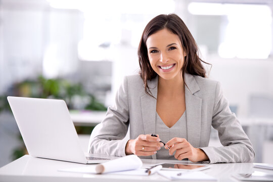 Shes made it. Shot of an attractive businesswoman sitting at her desk in an office.