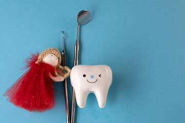 tooth Fairy. tooth figurine and tooth fairy nearby and dentist tools top view top view. Copy space...