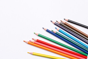 colored pencils are scattered on a white background. supplies for creativity and study