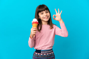 Little girl with a cornet ice cream isolated on blue background showing ok sign with fingers