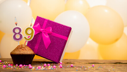  Happy birthday with pink gift box for 89 year old woman. Beautiful birthday card with cupcake and burning candle number eighty nine