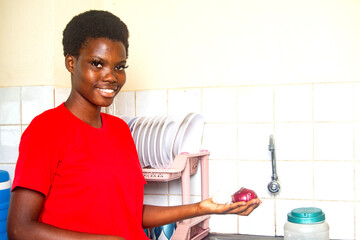 Fototapeta na wymiar beautiful young girl holding onion in the kitchen smiling.
