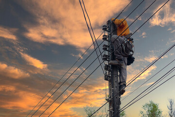 An electrician is climbing an electric pole to install and repair wires as it nears dusk.