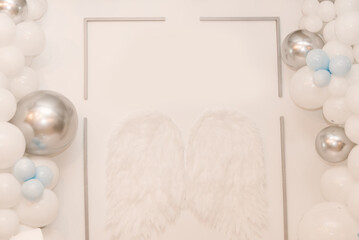 Beautiful white photo zone with balloons and angel wings