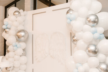 Fototapeta na wymiar Beautiful white photo zone with balloons and angel wings