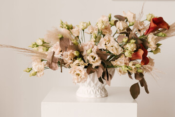 Beautiful flower arrangement in a pot and a bouquet on a light background