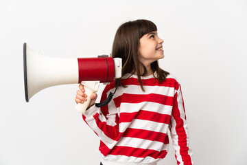 Little girl isolated on white background holding a megaphone and looking up while smiling