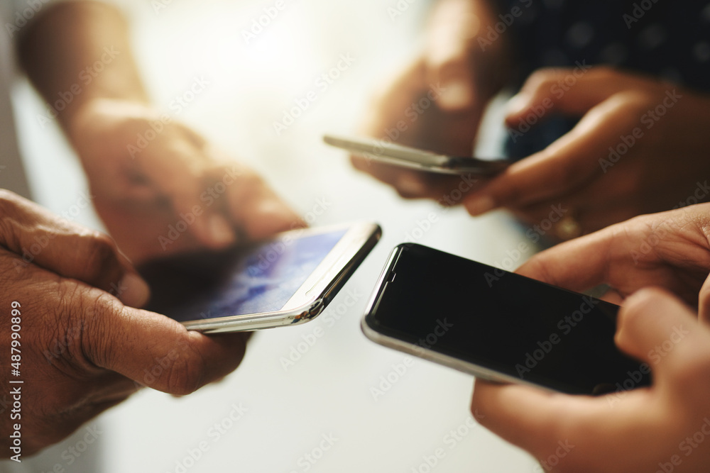 Poster get connected and stay in the know. closeup shot of a group of unrecognizable businesspeople using t