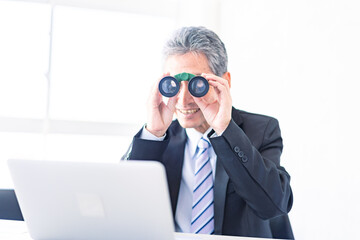 双眼鏡でパソコンを検証する男性