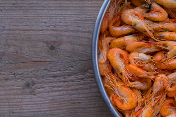 The top view prawns is a seafood. Bring it to boil until cooked to make an orange color look appetizing. In silver tray That was placed on brown wooden block. Copy space