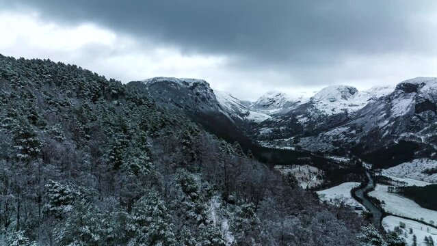 Backwards drone hyperlapse - cinematic reveal of snow-covered alpine valley