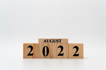 August 2022 written on wooden blocks isolated on white background with copy space