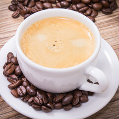 Coffee in white cup and roasted dark coffee beans