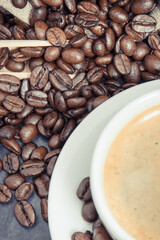 White cup of coffee and roasted fragrant dark coffee grains