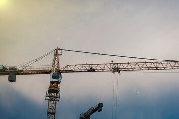 construction crane on the background of the sunset, the concept of building a residential area.