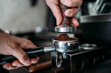 Frisch gemahlener Kaffee wird in Siebträger Maschine verarbeitet Nahaufnahme
