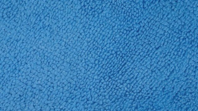 Close up: blue microfiber cleaning cloth on rotating surface - macro, top view. Abstract, pattern, texture, background and cleaning equipment for housework concept