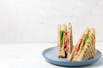 sandwich with ham cheese tomatoes lettuce onions on plate. Classic club sandwich with whole grain bread