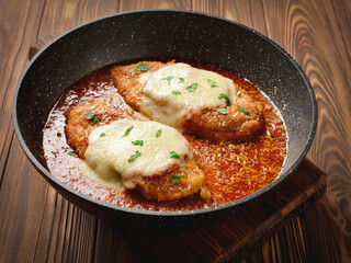 Frying pan with freshly cooked chicken parmesan - obrazy, fototapety, plakaty