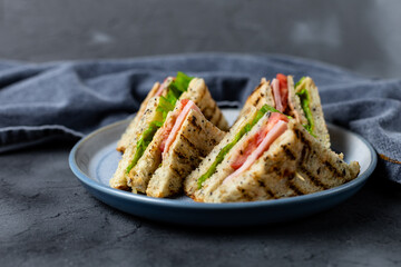 sandwich with ham cheese tomatoes lettuce onions on plate. Classic club sandwich with whole grain bread