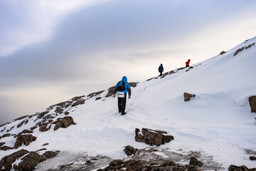 Fototapeta na wymiar Teriberka, Russia. Tourists climb the mountains