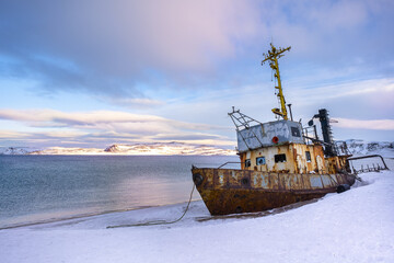 Sea and abandoned old ship, boat in the snow. Winter landscape in Russia, Kola Peninsula, Teriberka