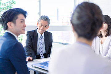 明るいオフィスで働くビジネスパーソン