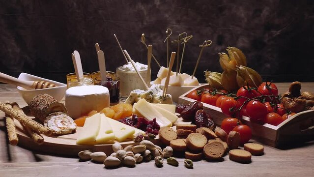 Presentation of cheeses and sweet and savory combinations on a wooden cutting board
