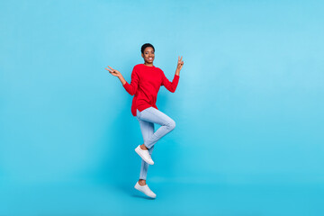 Fototapeta na wymiar Full size photo of jumping nonbinary girl showing v-sign say hello meet friends isolated on blue color background