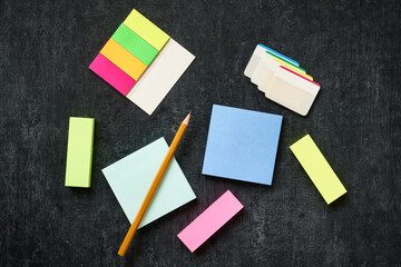 Blank paper self-adhesive multicolored sticks on a dark background