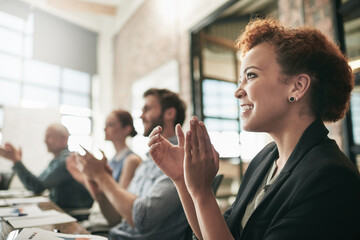 Keep an open mind to all ideas and comments shared. Shot of a team of businesspeople clapping hands...