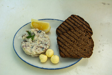Traditional Jewish appetizer, called Vorschmack or forshmak, made as a pate with chopped salty herring, hard-boiled egg, onion and grated fresh apple served with bread, butter and lemon in Moscow
