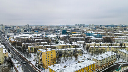 Aerial view of houses and road in the large city. Winter landscape. Residential areas in central of Minsk in the snow.