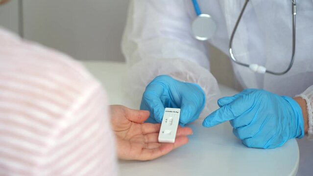 Doctors give rapid antigen test for covid-19 to female patient in clinic. Results of research on coronavirus test. Quick swab method to SARS-CoV-2. PCR