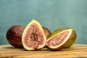 Fresh figs cut in half on wooden background with copy space