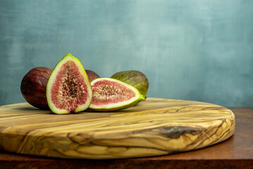 Fresh figs cut in half on wooden background with copy space