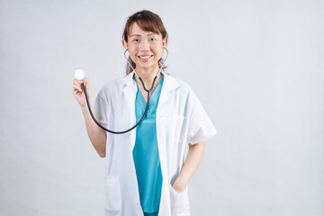 Happy beautiful female doctor in medical coat standing with crossed arms isolated on white.Asia look