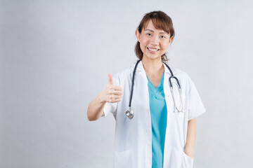 Happy beautiful female doctor in medical coat standing with crossed arms isolated on white.Asia look