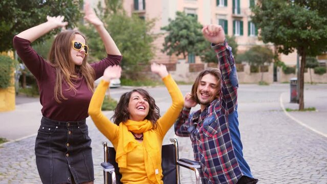 fun despite disability - young disabled woman enjoys dancing with his friends