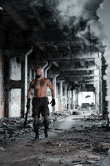 a soldier in military clothes poses in an abandoned building with a gun in his hands