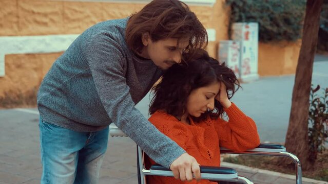 empathy, closeness - young man tries to comfort his girlfriend with paraplegia